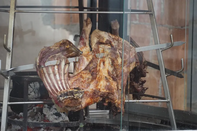 Antikristo lamb slow-roasted upright around an open fire