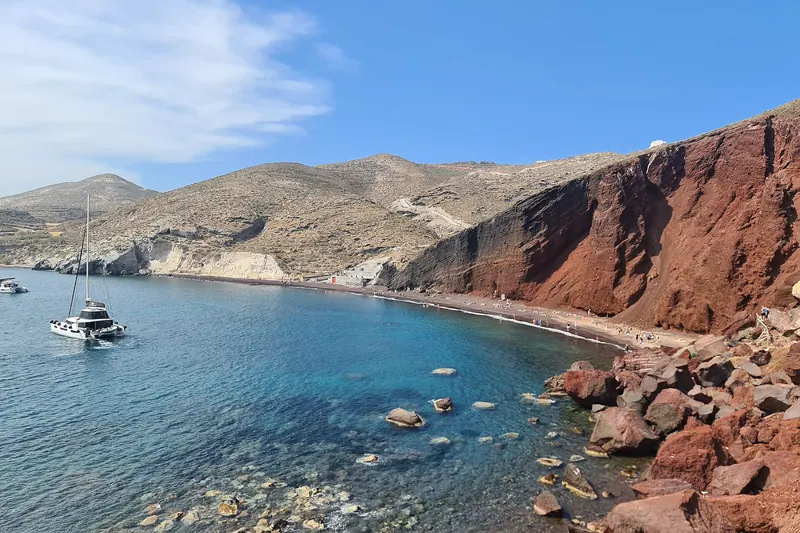 Red Beach beneath dramatic red volcanic cliffs