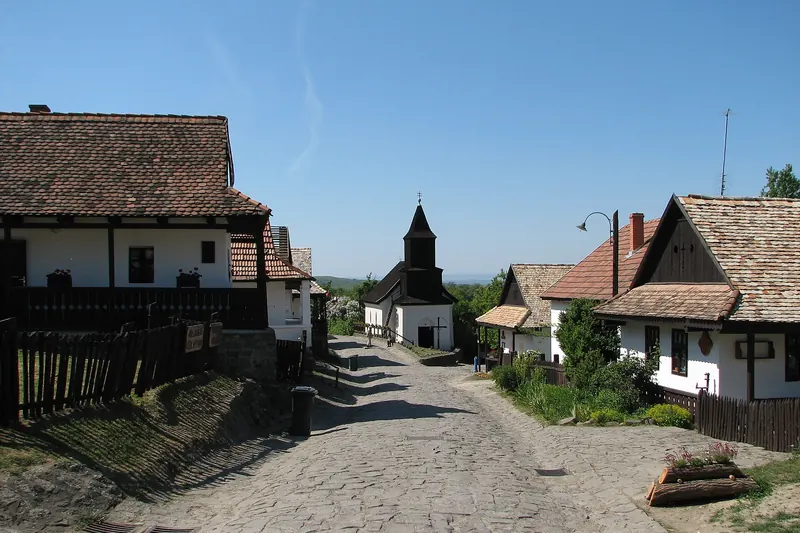 Whitewashed houses with wooden details on the main street of Hollókő Old Village