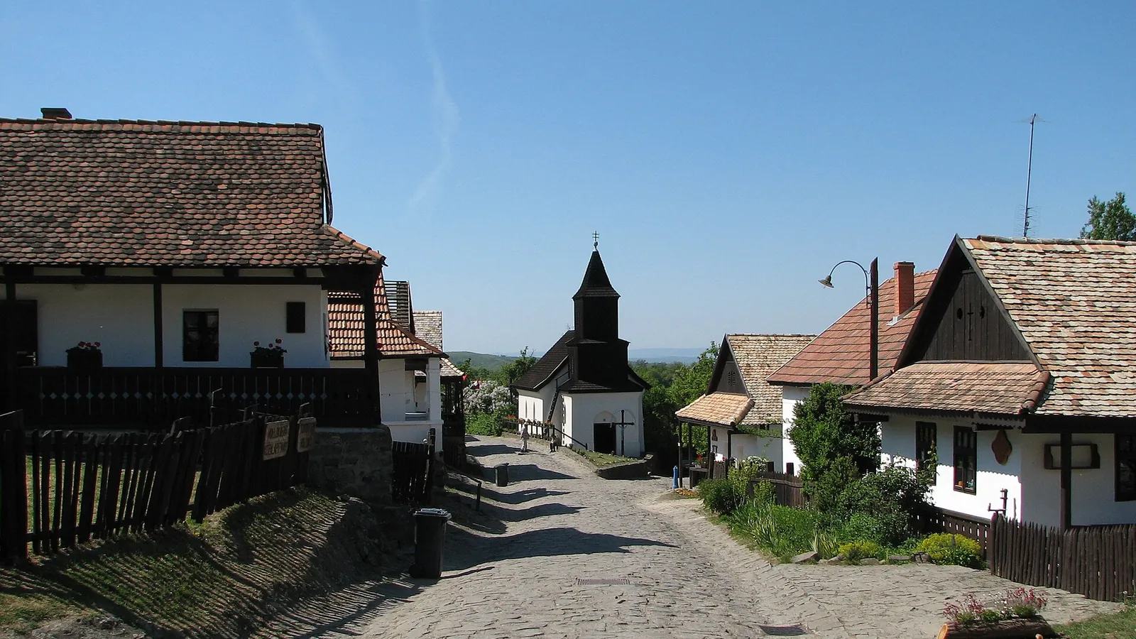Whitewashed houses with wooden details on the main street of Hollókő Old Village