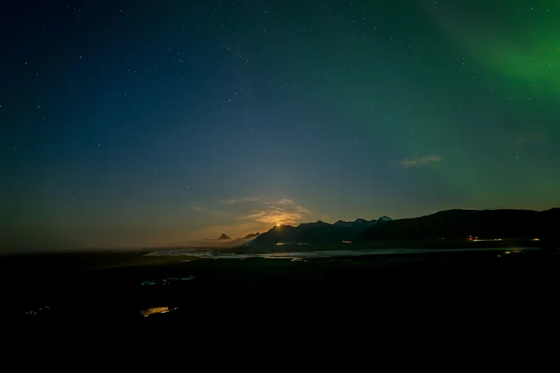 The aurora borealis glowing green over an Icelandic landscape