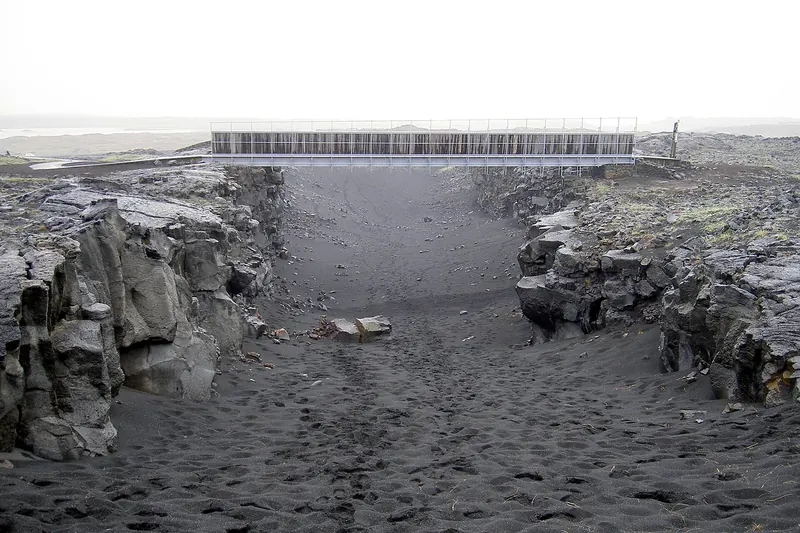 A small footbridge over a rift symbolising the border of two tectonic plates