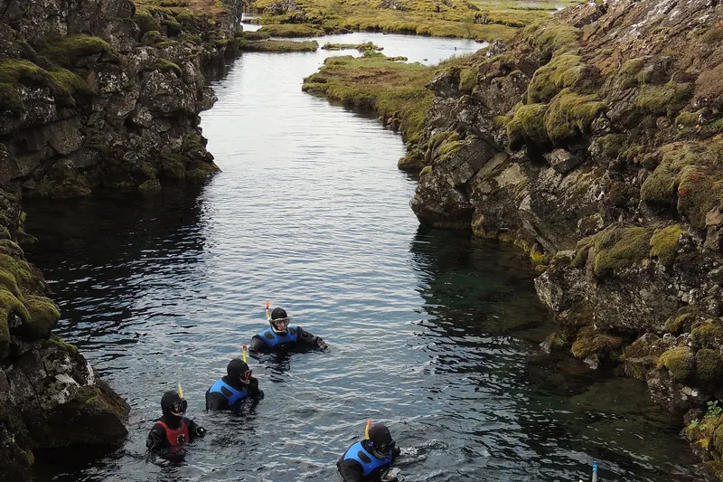 A snorkeller in the crystal-clear water of the Silfra fissure