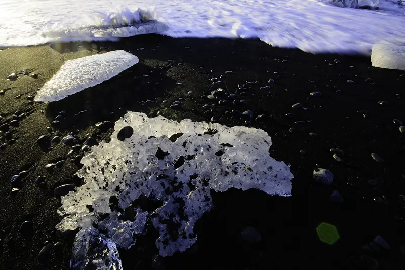 Ice chunks scattered across the black sand of Diamond Beach