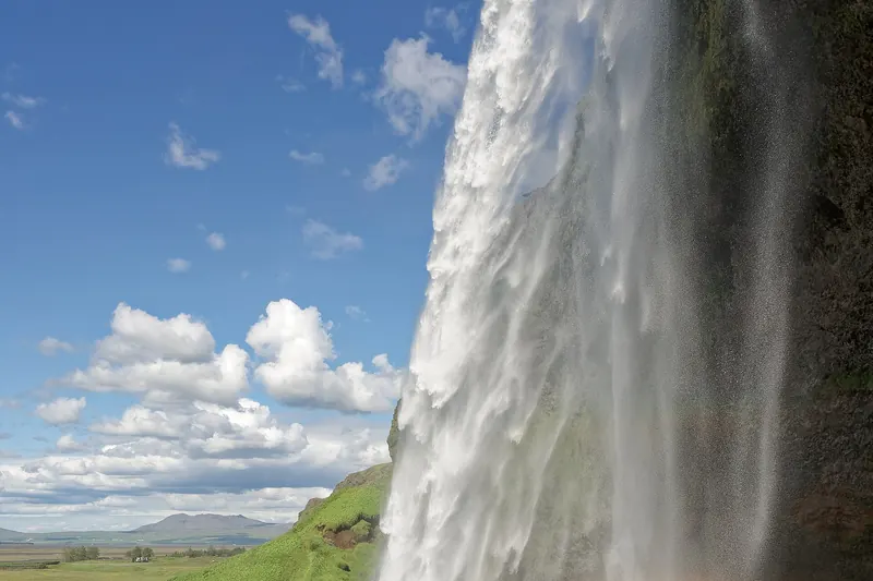 Walking the path behind Seljalandsfoss waterfall
