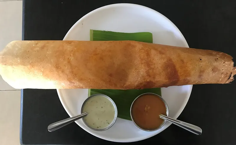 A crisp masala dosa filled with spiced potato and served with chutneys