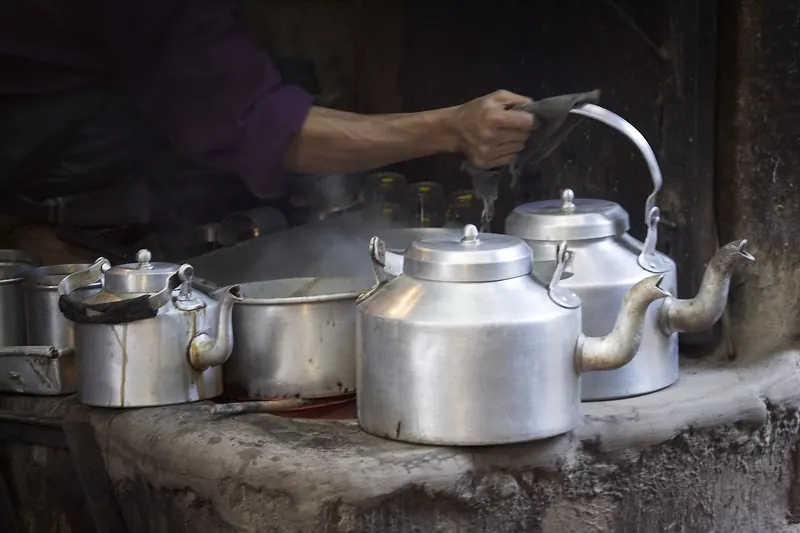 A vendor pouring chai into small clay cups in Varanasi