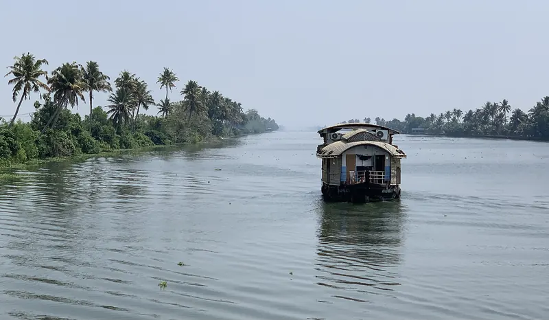 A traditional houseboat on the palm-lined backwaters near Alleppey in Kerala