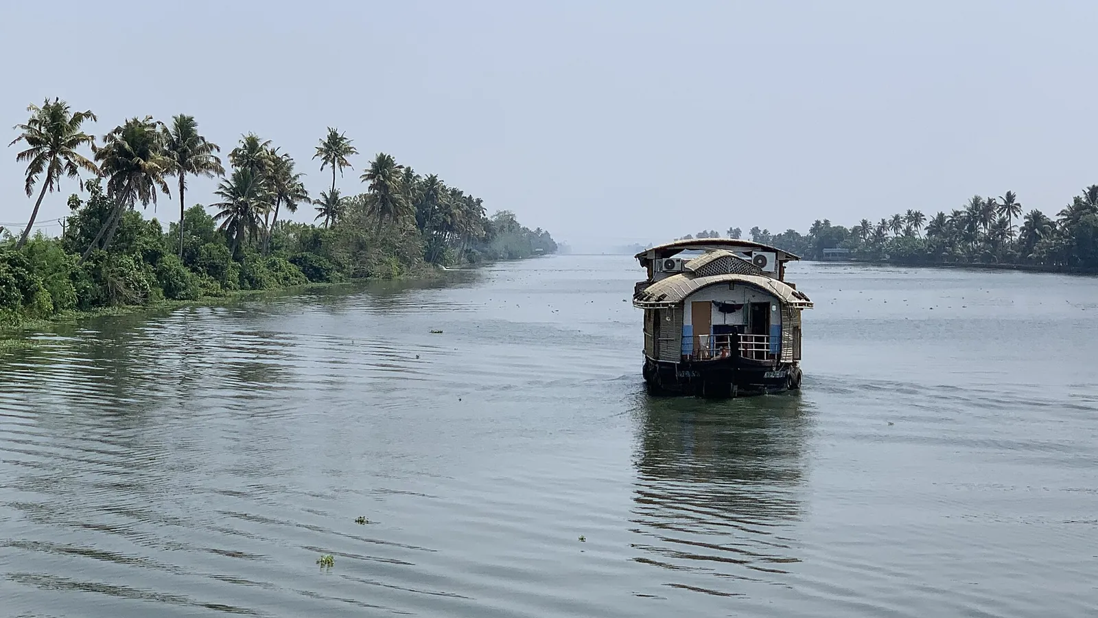 A traditional houseboat on the palm-lined backwaters near Alleppey in Kerala