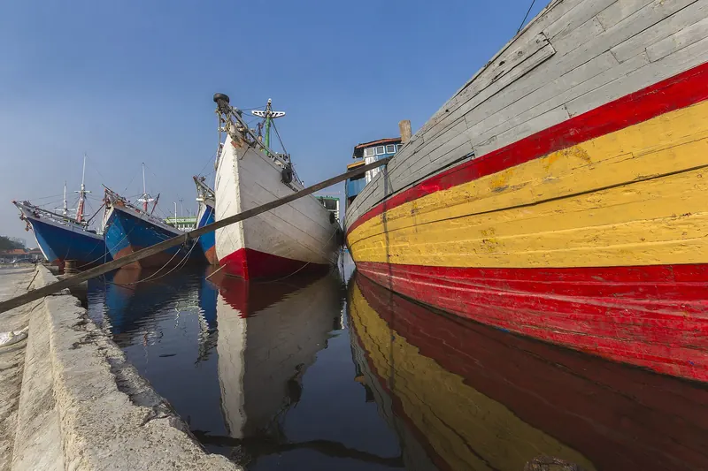 Traditional wooden phinisi schooners docked at Sunda Kelapa harbour