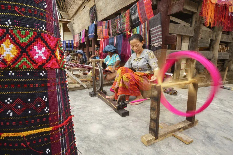 A weaver working on traditional ulos cloth