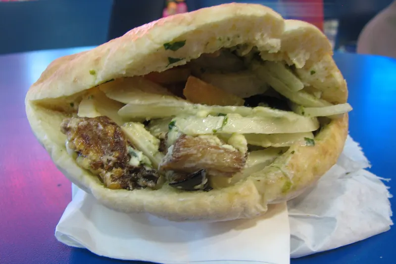 A sabich sandwich of pita filled with eggplant, egg and salad