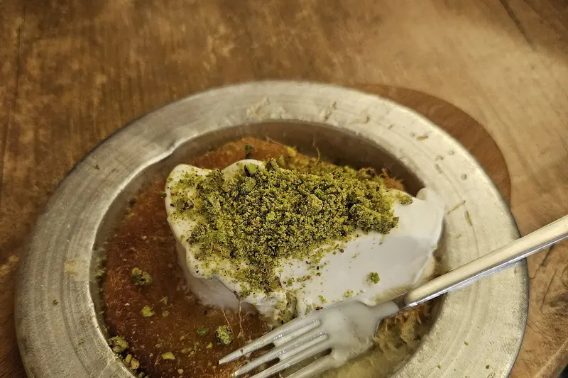 A tray of hot knafeh, a cheese pastry with syrup and pistachios
