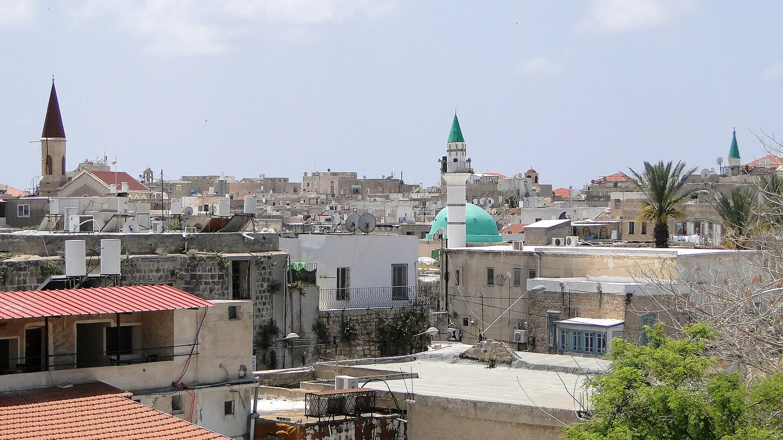 The old city of Acre seen from its sea walls, with the harbour and minarets