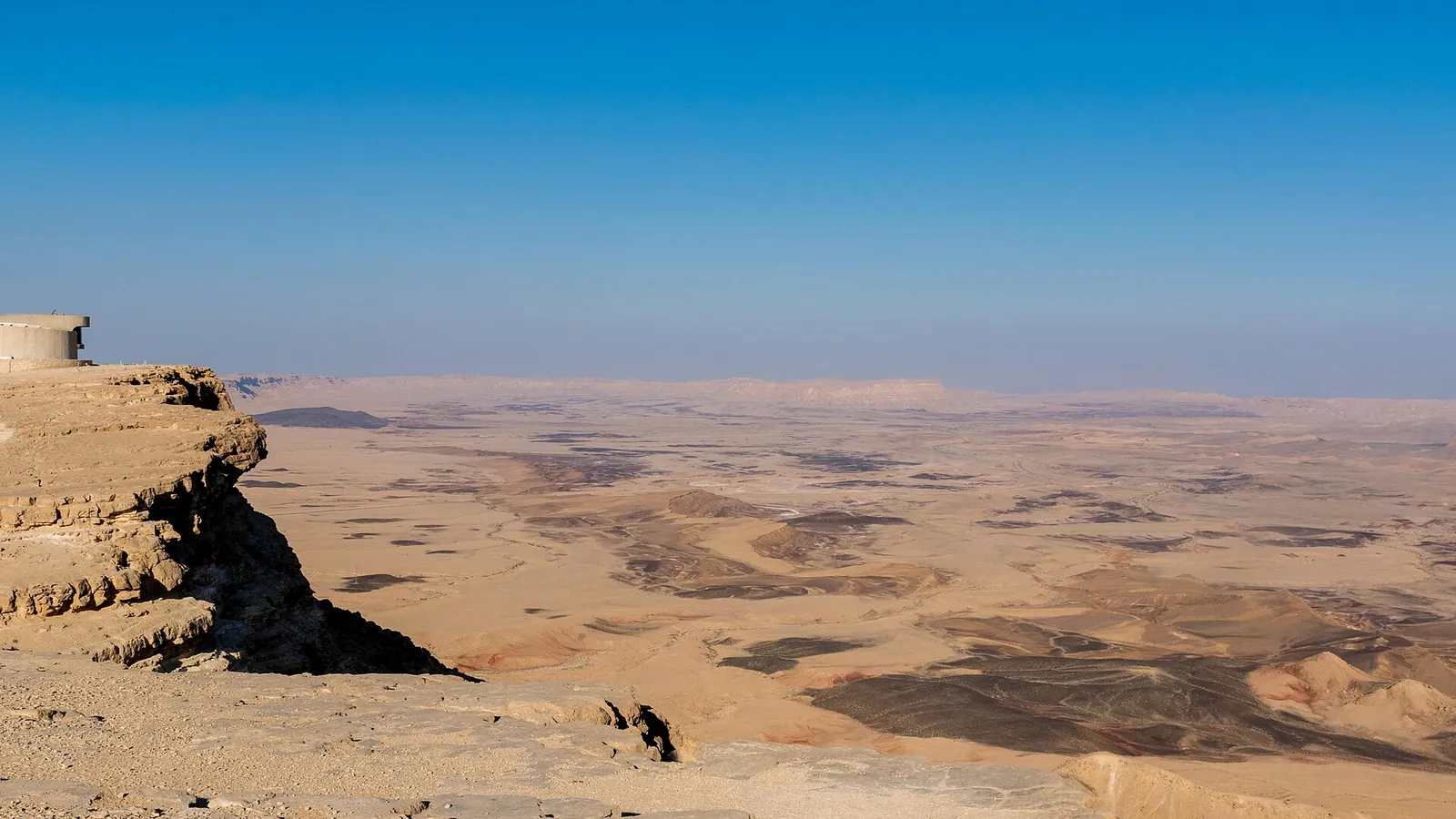 Black rocks and desert cliffs in the Ramon Crater at Mitzpe Ramon