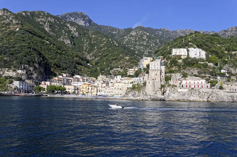 A boat passing a coastal town on the Amalfi Coast, seen from the water