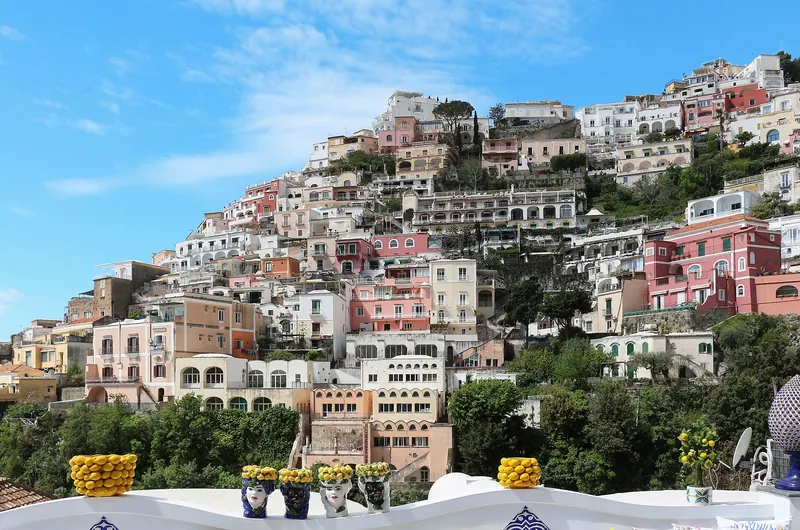 The pastel houses of Positano stacked down a cliff to the beach on the Amalfi Coast