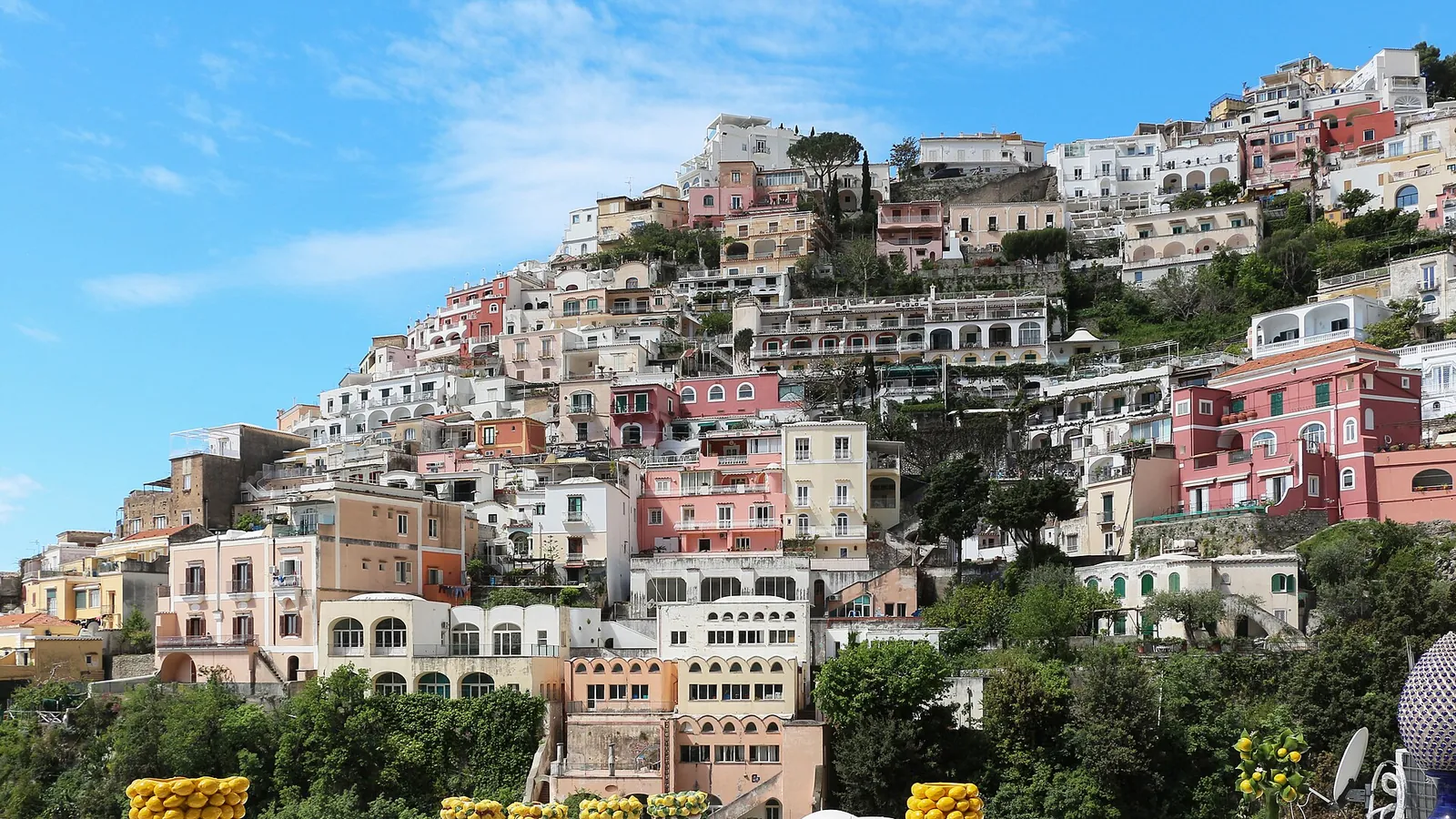 The pastel houses of Positano stacked down a cliff to the beach on the Amalfi Coast