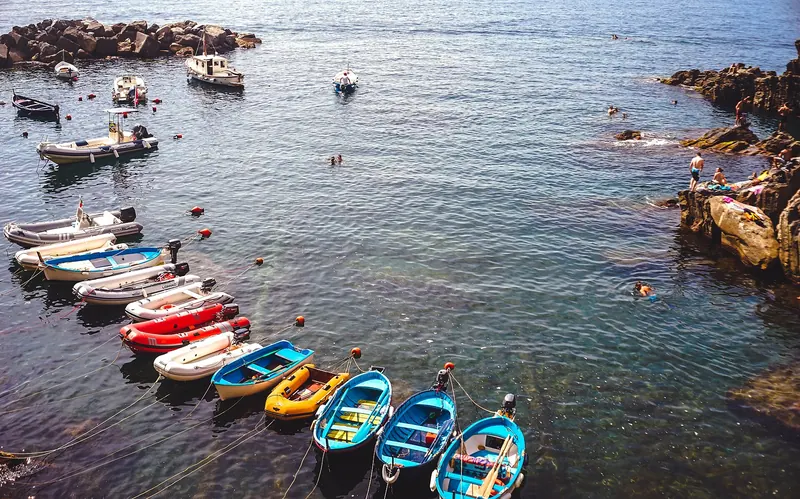 Riomaggiore's small harbour, with boats hauled up the slipway between tall coloured houses