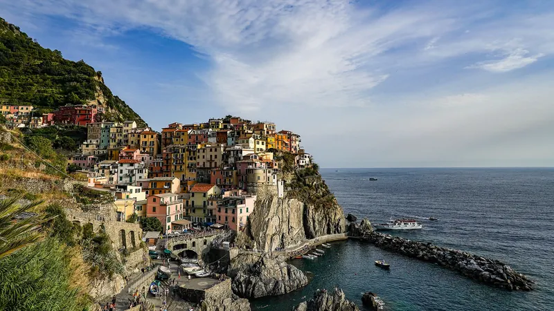 Manarola's houses piled on a black rock promontory above the sea, with vineyard terraces behind