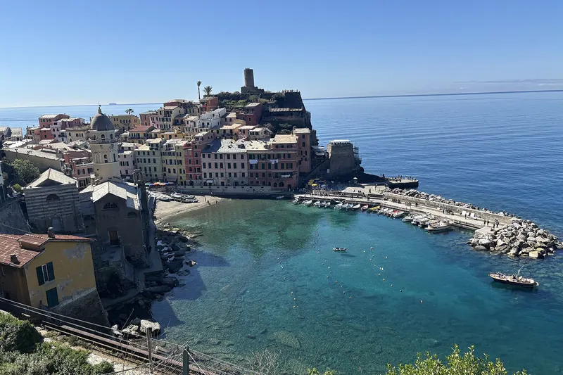 Vernazza's natural harbour ringed by tall houses, with the castle tower above