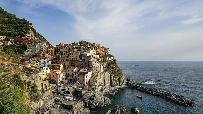 The stacked houses of Manarola above the sea, with terraced vineyards on the cliffs behind