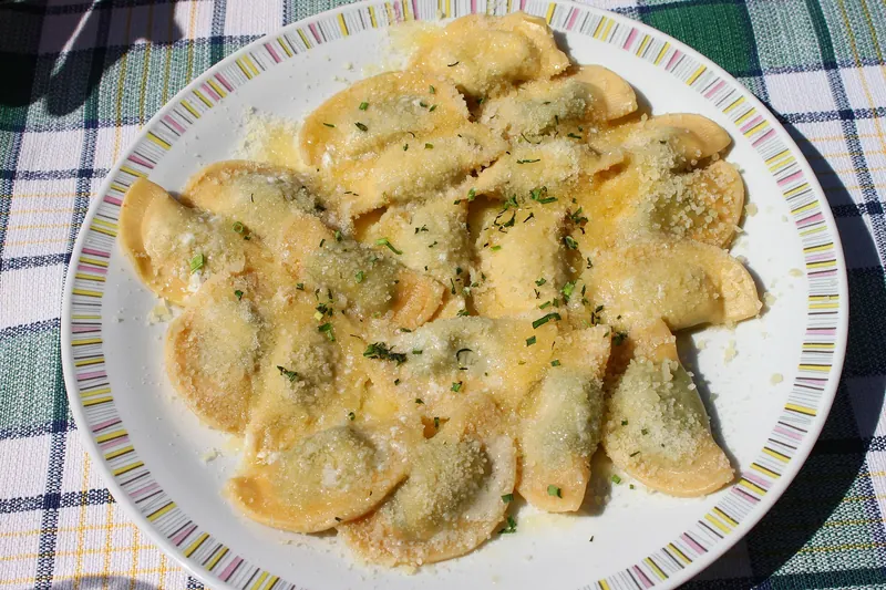 Schlutzkrapfen, half-moon pasta filled with spinach and ricotta, in butter and Parmesan