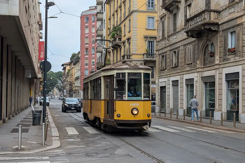 A vintage 1920s-style tram operating Route 1 through central Milan