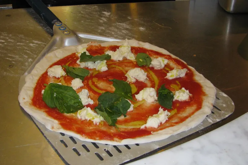 A soft, blistered Neapolitan pizza fresh from a wood oven