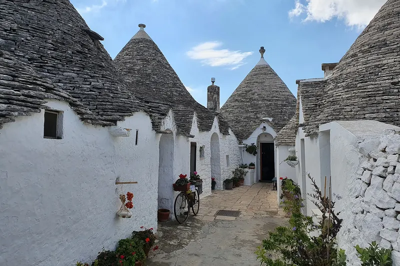 A street of whitewashed trulli with conical dry-stone roofs in Alberobello