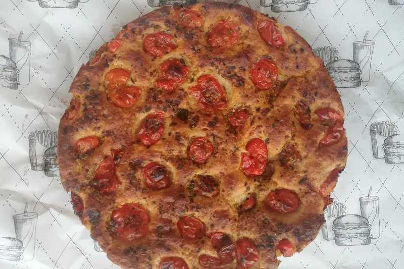 Focaccia barese, dimpled with cherry tomatoes and olives