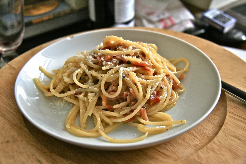 A plate of spaghetti alla carbonara, glossy with egg, guanciale and pecorino