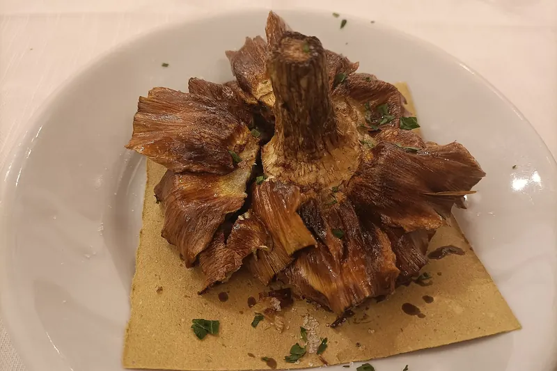 A whole carciofo alla giudia, deep-fried until its leaves crisp like petals