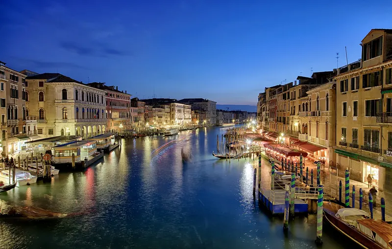 Palace windows lit along the Grand Canal after dark