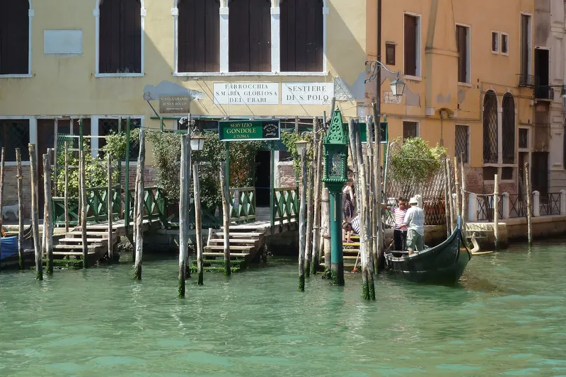 A gondola traghetto ferrying standing passengers across the Grand Canal at San Tomà