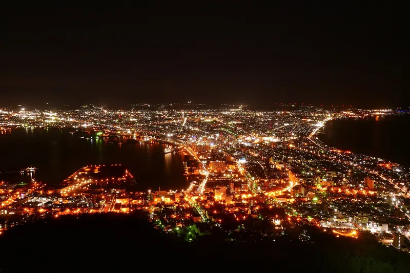 Hakodate's hourglass-shaped harbour illuminated at night, seen from Mount Hakodate
