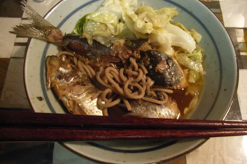 A bowl of soba noodles in a light broth