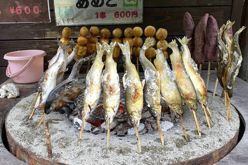 Whole freshwater fish grilled on sticks, the traditional preparation for mountain-stream trout