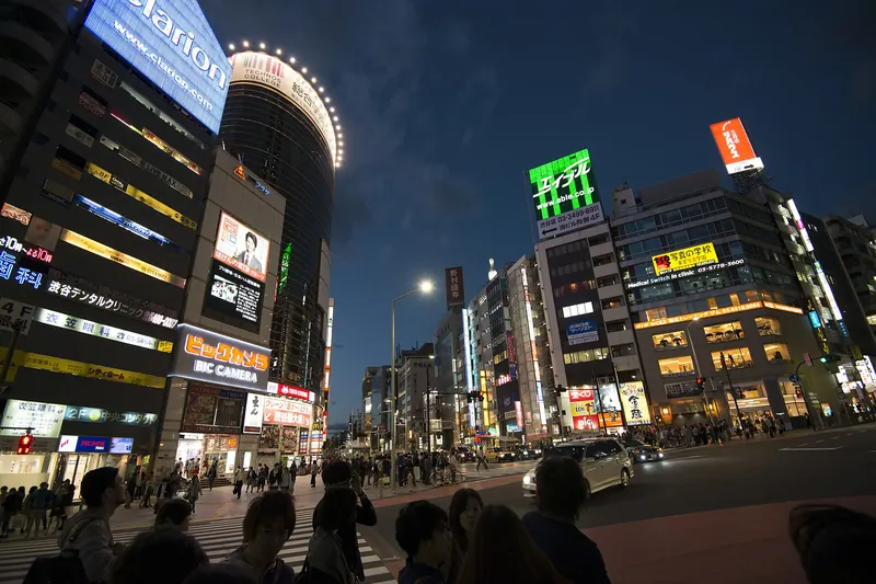 Tokyo's Shibuya streets at night, illuminated by neon signage