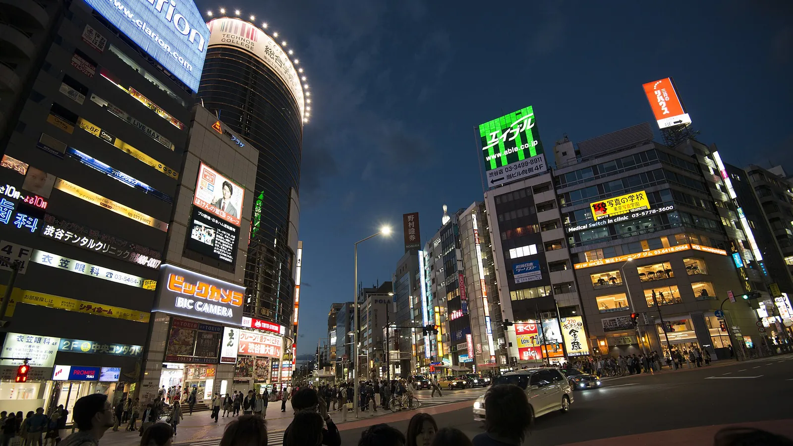 Tokyo's Shibuya streets at night, illuminated by neon signage