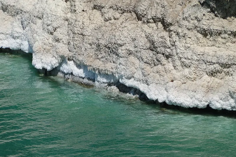 The still blue waters of the Dead Sea on the Jordanian shore