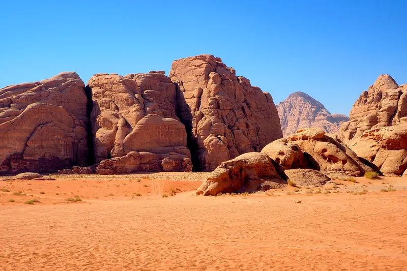 Sandstone mountains rising from the red sand of Wadi Rum