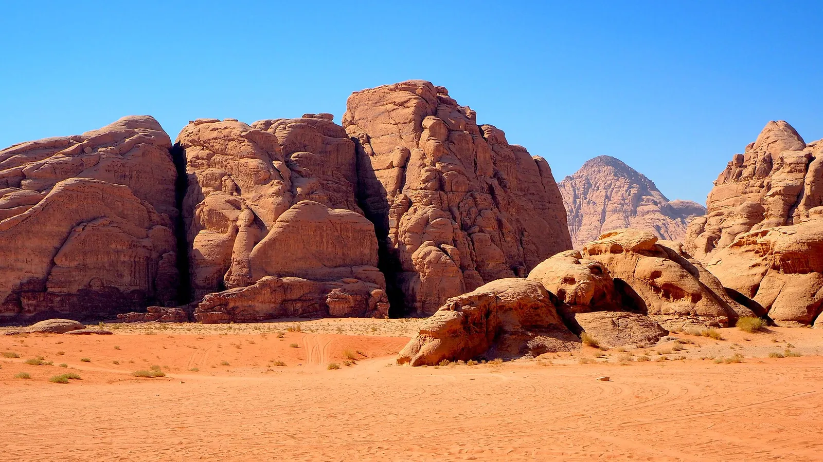 Sandstone mountains rising from the red sand of Wadi Rum