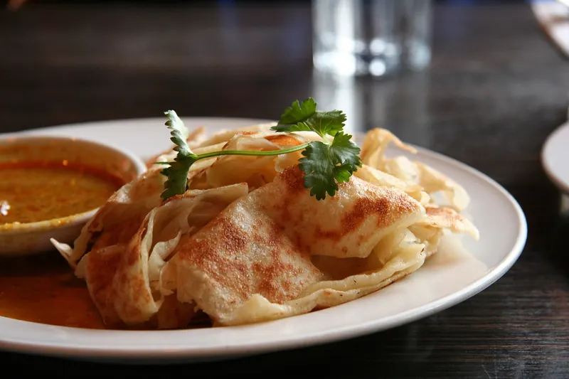 Roti canai, a flaky flatbread served with curry