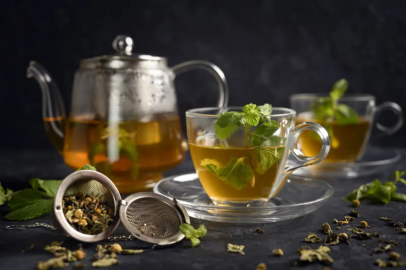 Moroccan mint tea poured from a silver pot into a small glass
