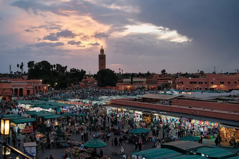 Jemaa el-Fnaa square in Marrakech at sunset with the Koutoubia minaret in the background