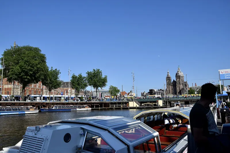 Gabled canal houses lining a tree-shaded Amsterdam canal