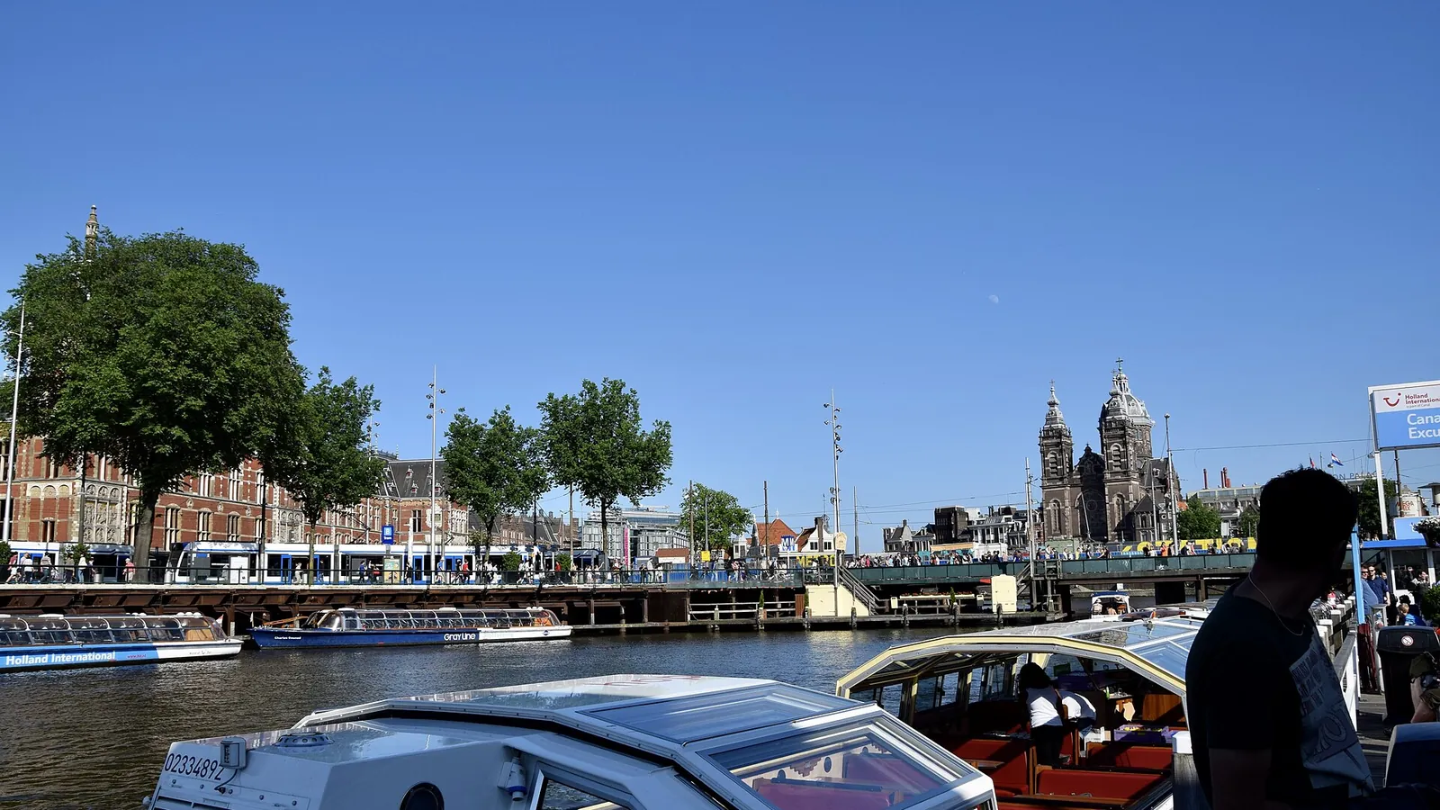 Gabled canal houses lining a tree-shaded Amsterdam canal