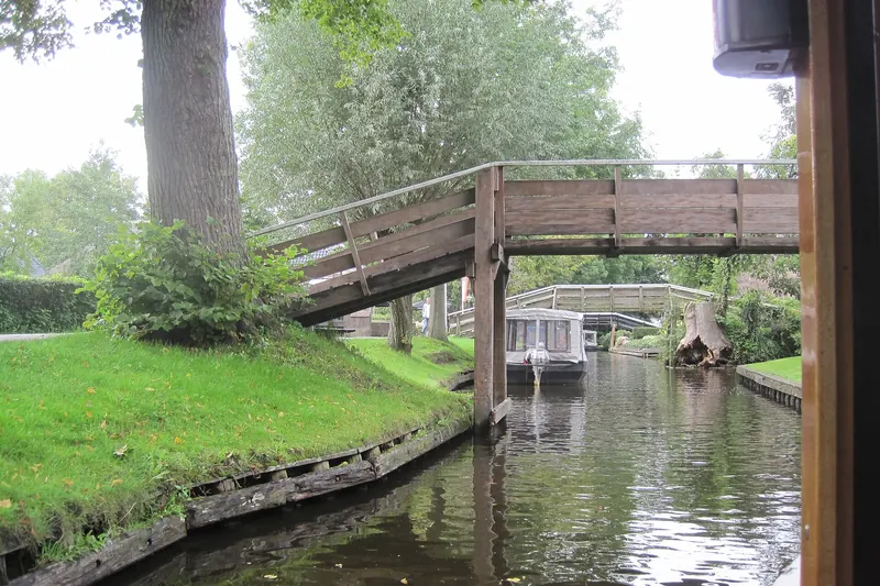 A traditional wooden footbridge crossing a canal in Giethoorn