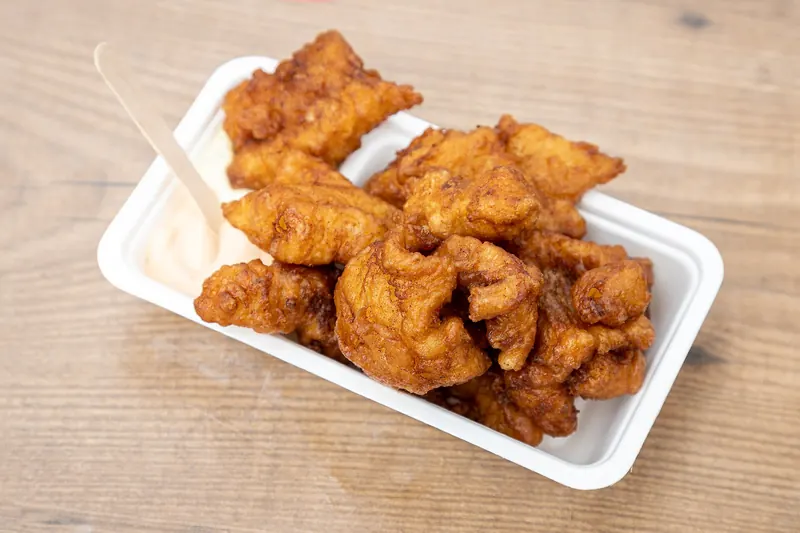 A portion of kibbeling, Dutch battered fried fish, served with sauce